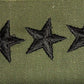 Besticktes US Army Rangabzeichen mit drei schwarzen Sternen auf olivgrünem Stoff, symbolisch für den Rang eines Brigade-Generals
